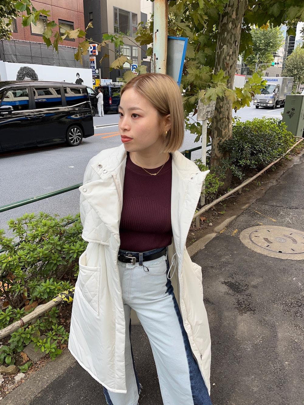 ホワイト系のダウンジャケット/コート、ブルー系のデニムパンツ、ブラウン系のニット/セーターを着用したレディースの秋コーディネートの5枚目の写真