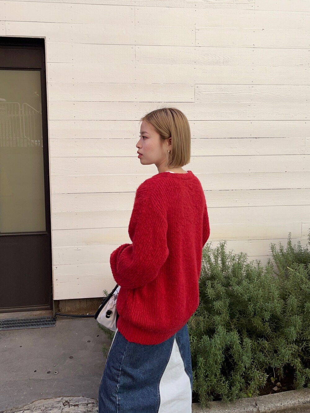 レッド系のカーディガン/ボレロ、ホワイト系のTシャツ/カットソー、ブルー系のスカートを着用したレディースの秋コーディネートの5枚目の写真