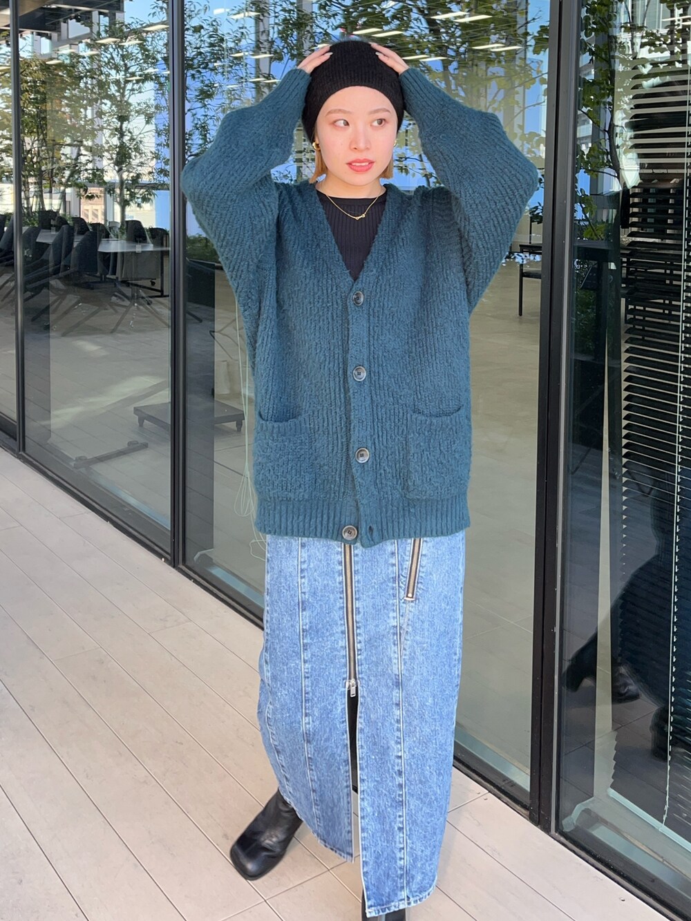 グリーン系のカーディガン/ボレロ、ブルー系のデニムスカートを着用したレディースの秋コーディネートの3枚目の写真