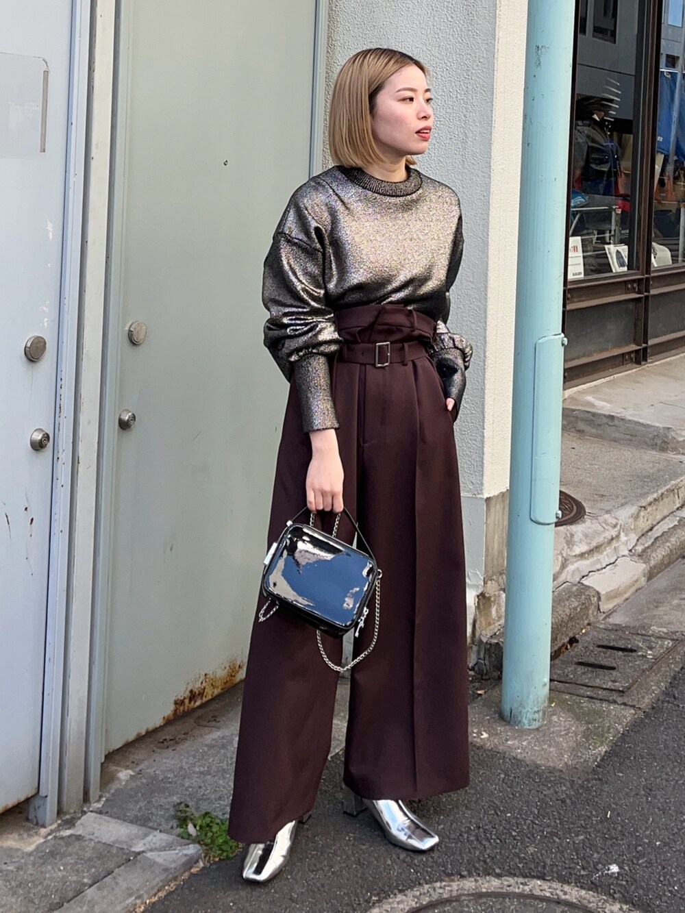 シルバー系のニット/セーター、ブラック系のショルダーバッグ、シルバー系のブーツを着用したレディースの冬コーディネートの2枚目の写真