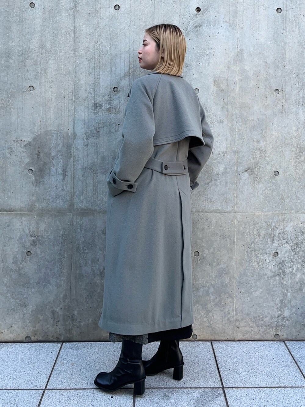 グリーン系のステンカラーコートを着用したレディースの冬コーディネートの3枚目の写真