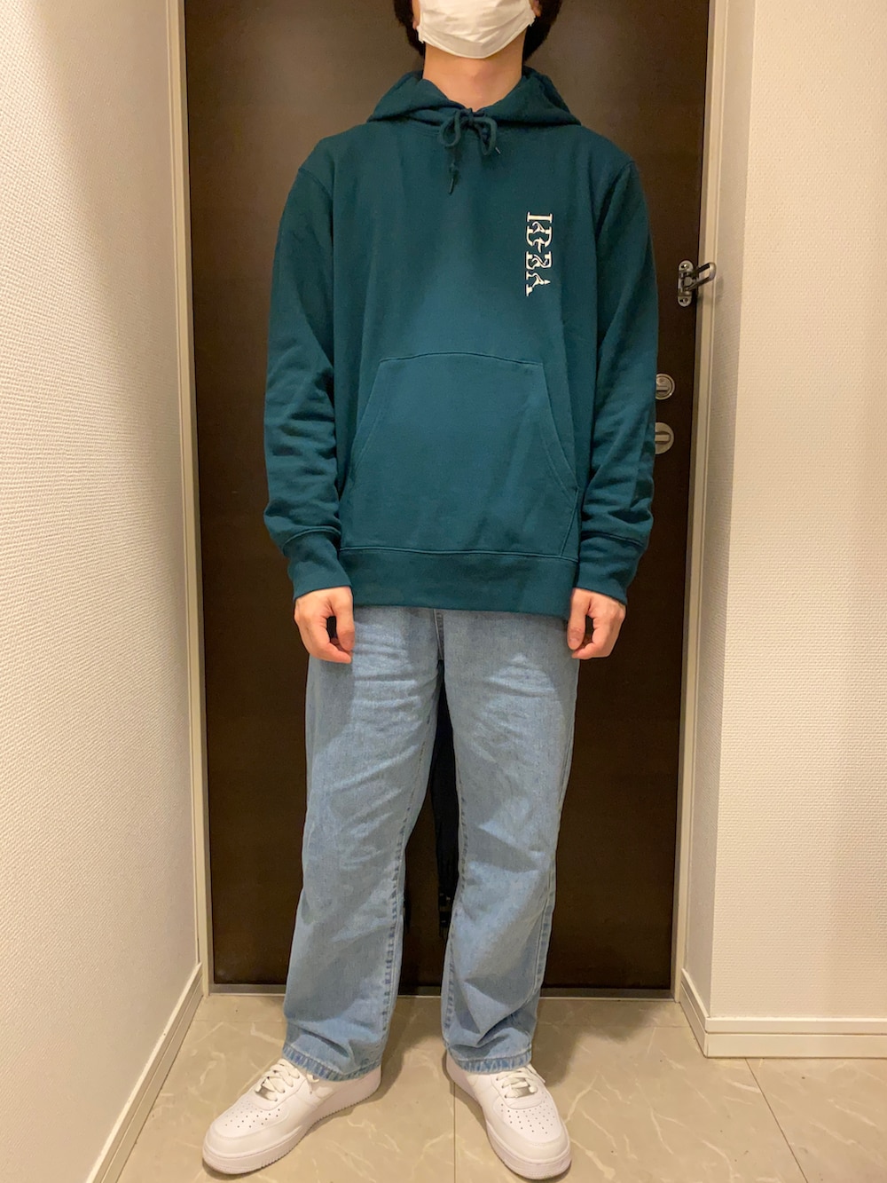 ブラック系のダウンジャケット/コート、グリーン系のパーカー、ブルー系のデニムパンツを着用したメンズの冬コーディネートの2枚目の写真