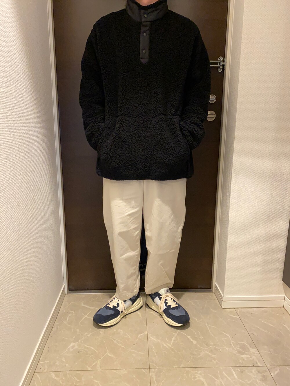 ブルー系のその他アウター、ブラック系のスウェット、ホワイト系のチノパンツを着用したメンズの冬コーディネートの2枚目の写真