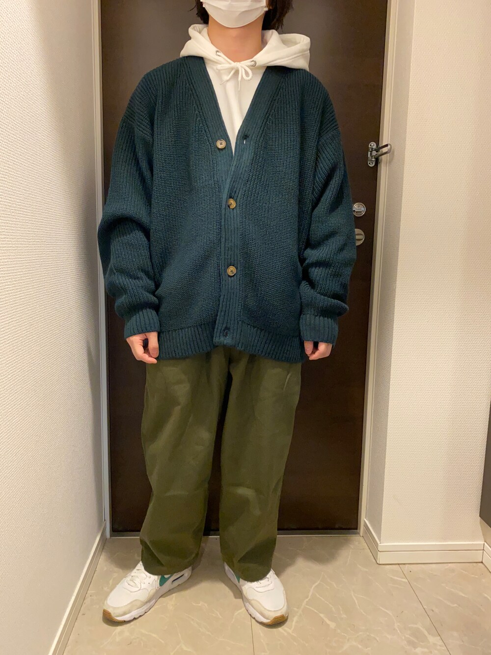 ホワイト系のパーカー、グリーン系のカーディガン/ボレロ、グリーン系のモッズコートを着用したメンズの春コーディネートの2枚目の写真