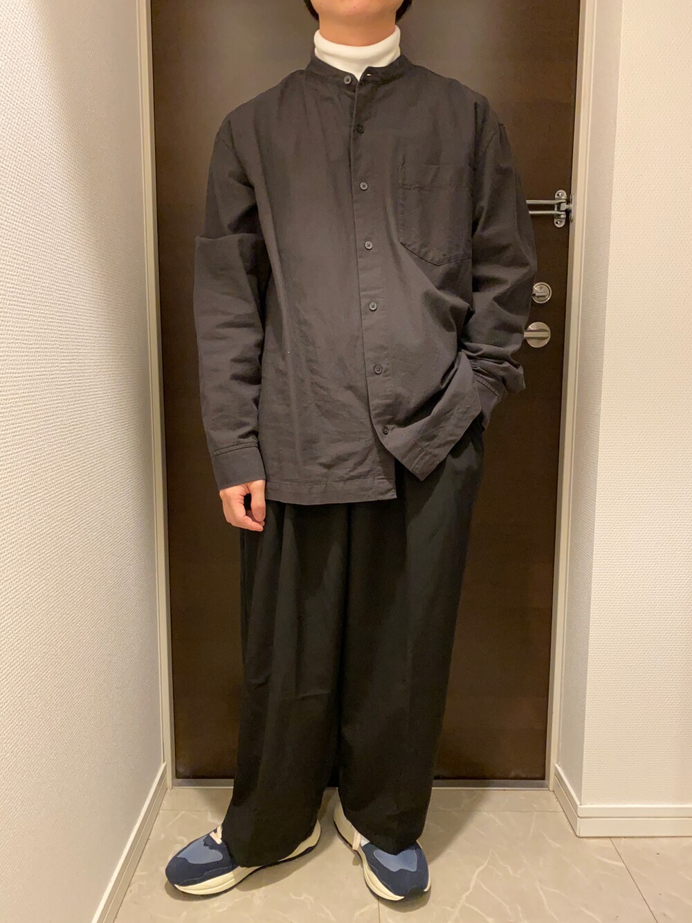 ホワイト系のTシャツ/カットソー、グレー系のシャツ/ブラウス、ブラック系のスラックスを着用したメンズの冬コーディネートの2枚目の写真