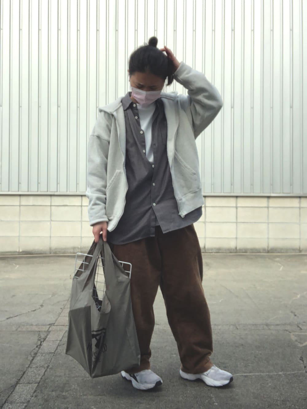 ブラウン系のその他パンツ、ホワイト系のスニーカー、グリーン系のエコバッグ/サブバッグを着用したレディースの春コーディネートの2枚目の写真