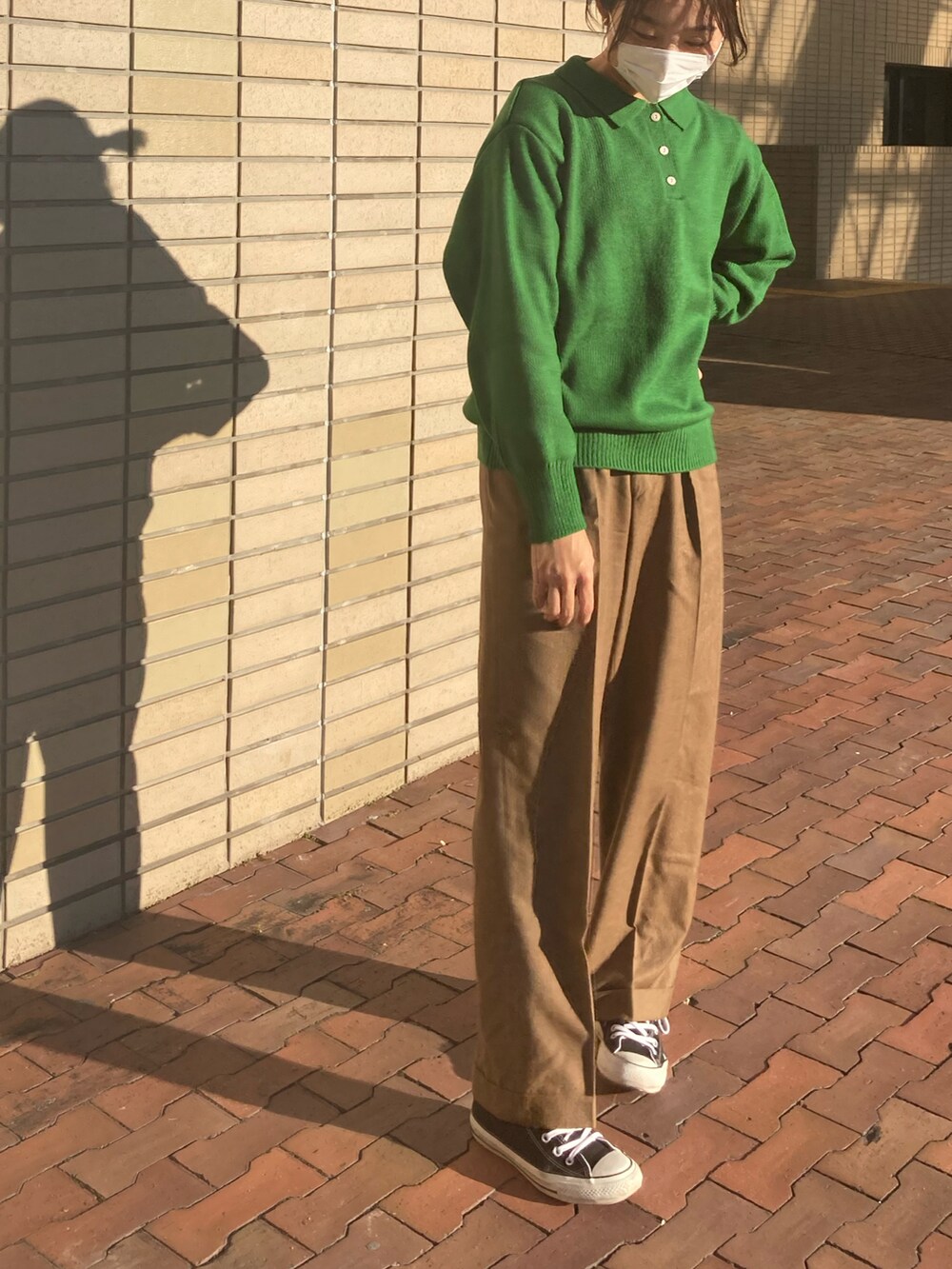 ブラック系のライダースジャケット、グリーン系のニット/セーター、ブラック系のスニーカーを着用したレディースの秋コーディネートの4枚目の写真