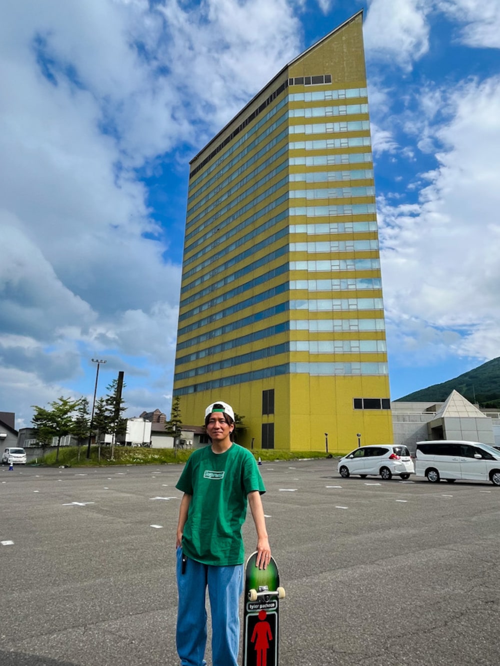 グリーン系のTシャツ/カットソー、ブルー系のデニムパンツ、グリーン系のスニーカーを着用したメンズの夏コーディネートの3枚目の写真