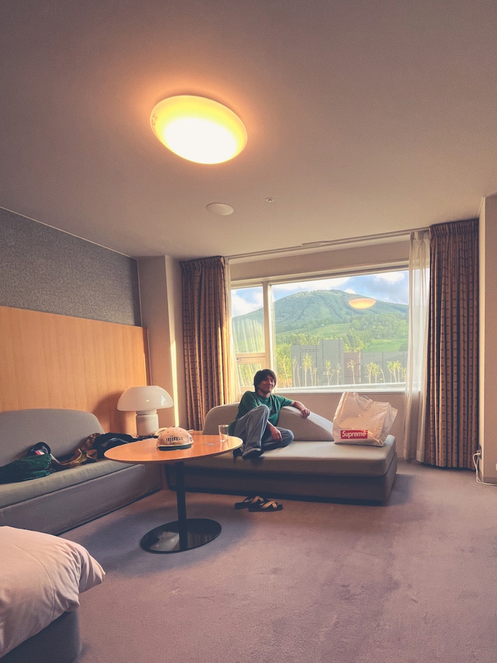 グリーン系のTシャツ/カットソー、ブルー系のデニムパンツ、グリーン系のスニーカーを着用したメンズの夏コーディネートの2枚目の写真