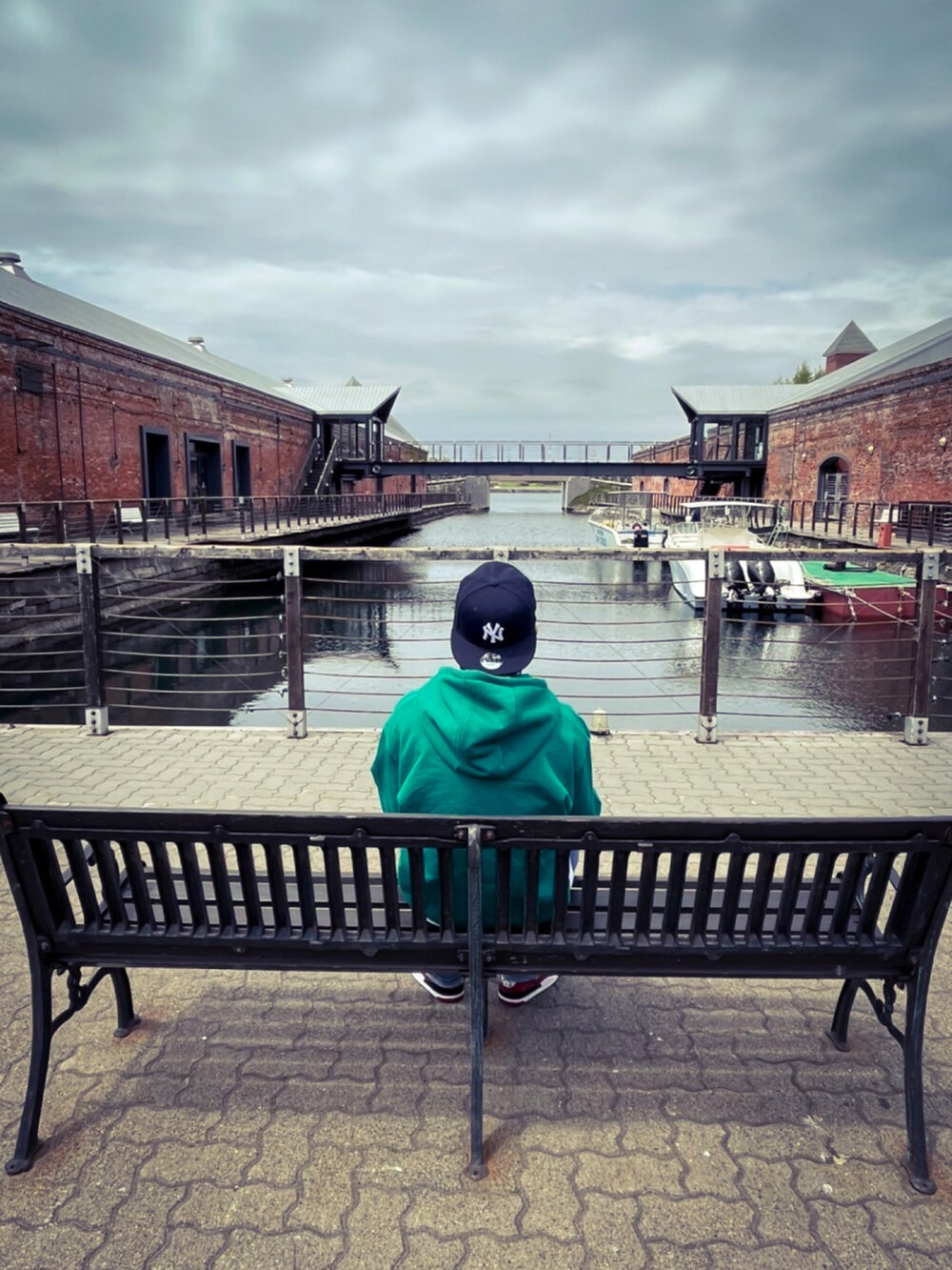 グリーン系のパーカー、ホワイト系のTシャツ/カットソー、ブルー系のデニムパンツを着用したメンズの春コーディネートの4枚目の写真