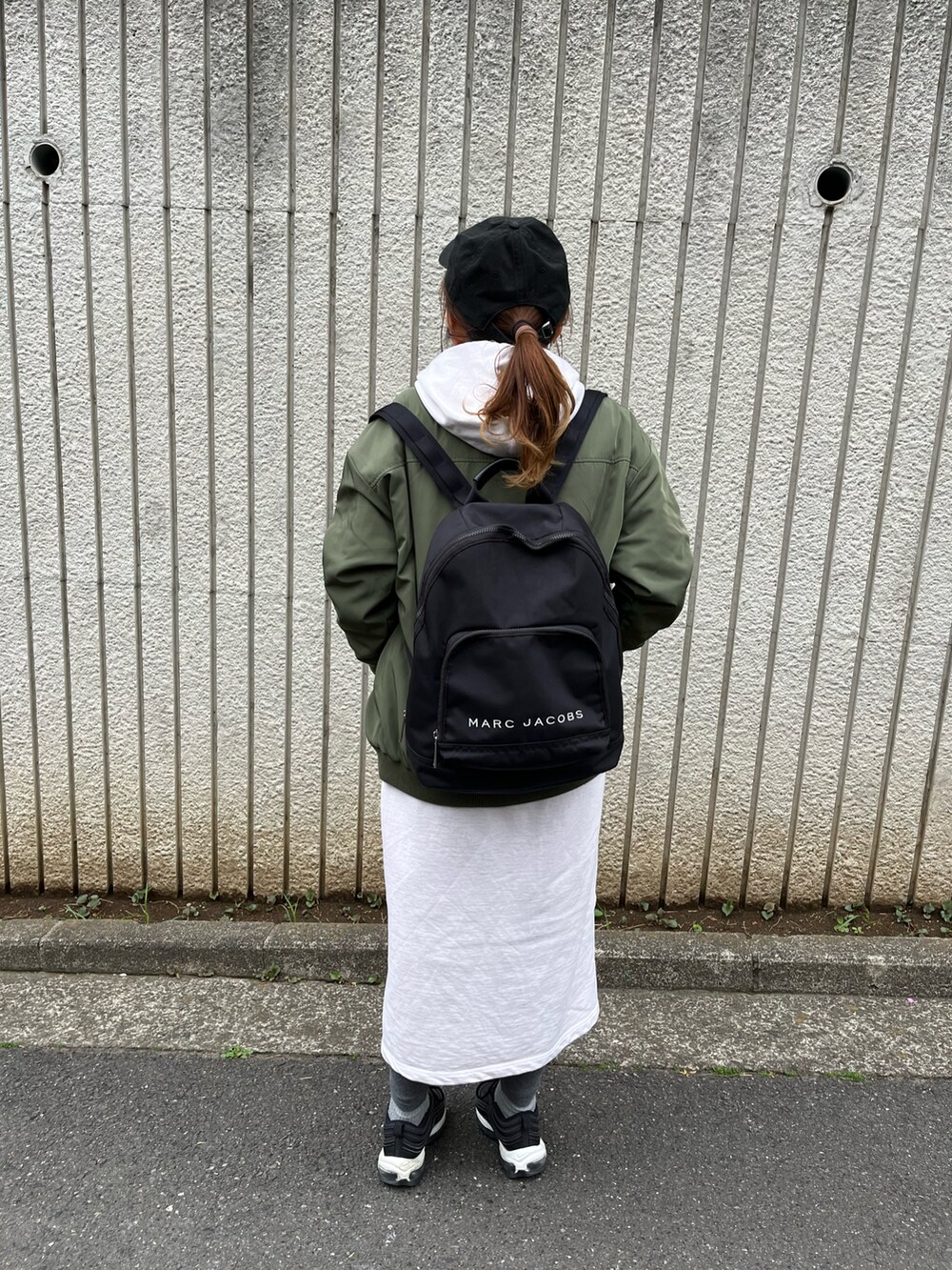 ブラック系のスニーカー、ベージュ系のワンピース、グリーン系のMA-1を着用したレディースの春コーディネートの3枚目の写真