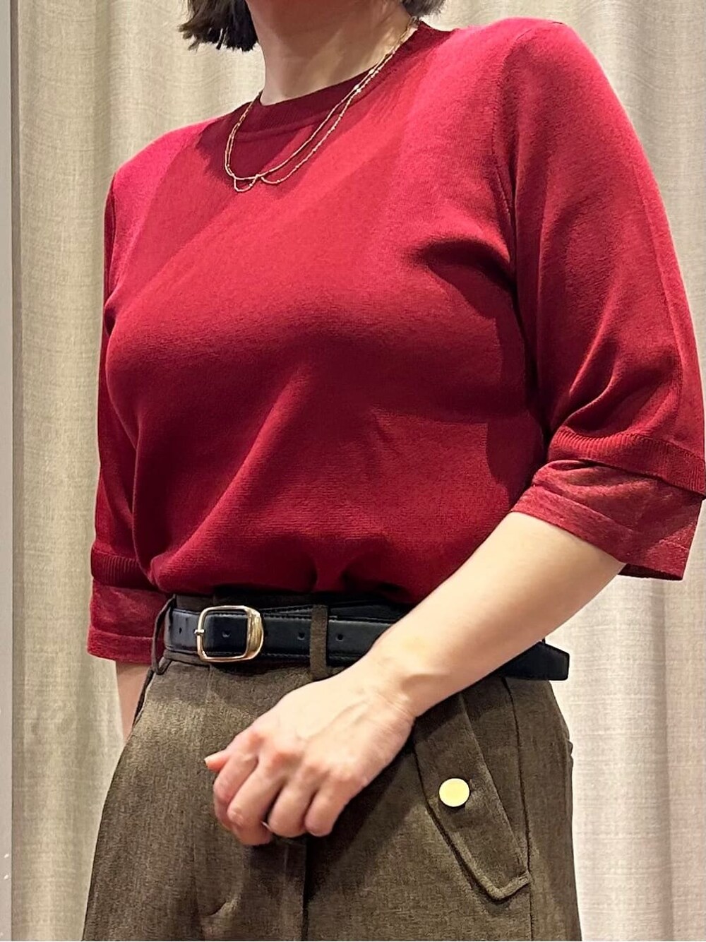 レッド系のニット/セーター、ブラウン系のその他パンツ、ゴールド系のネックレスを着用したレディースの秋コーディネートの4枚目の写真