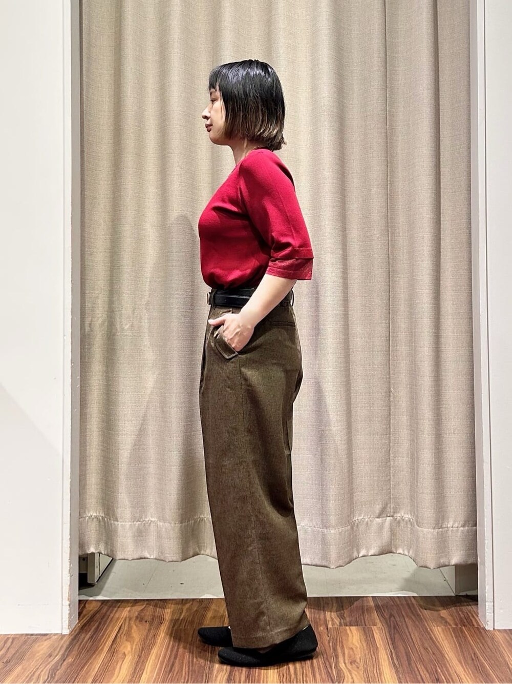 レッド系のニット/セーター、ブラウン系のその他パンツ、ゴールド系のネックレスを着用したレディースの秋コーディネートの2枚目の写真
