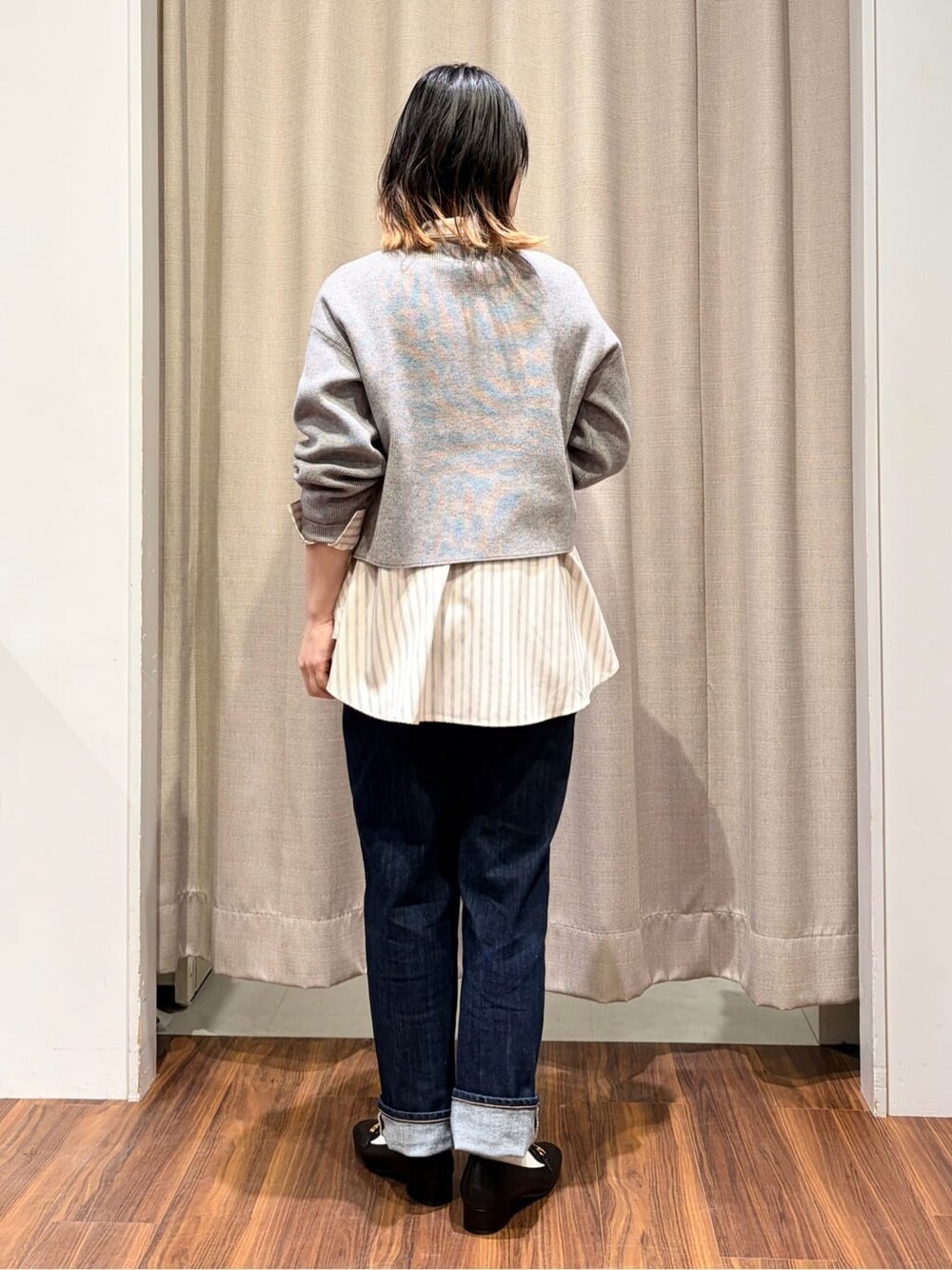 グレー系のニット/セーター、ピンク系のシャツ/ブラウス、ブルー系のデニムパンツを着用したレディースの冬コーディネートの3枚目の写真