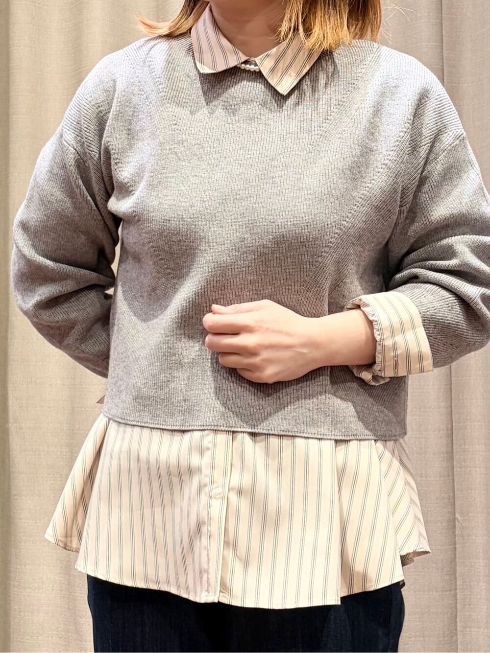 グレー系のニット/セーター、ピンク系のシャツ/ブラウス、ブルー系のデニムパンツを着用したレディースの冬コーディネートの4枚目の写真