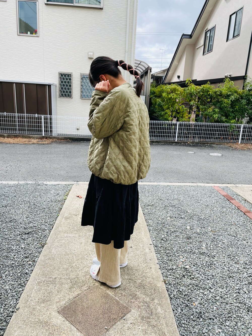 グリーン系のブルゾン、ブラック系のワンピース、ベージュ系のその他パンツを着用したキッズの春コーディネートの2枚目の写真