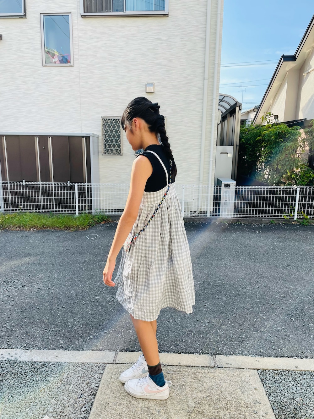 グレー系のワンピース/ドレス、ホワイト系のスニーカー、ブラック系のタンクトップを着用したキッズの秋コーディネートの2枚目の写真