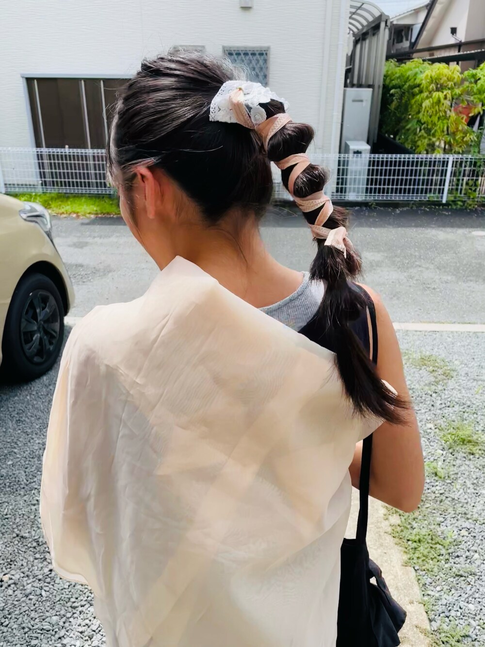 ブラック系のバッグ、ブラック系のワンピース、ホワイト系のスニーカーを着用したキッズの夏コーディネートの3枚目の写真