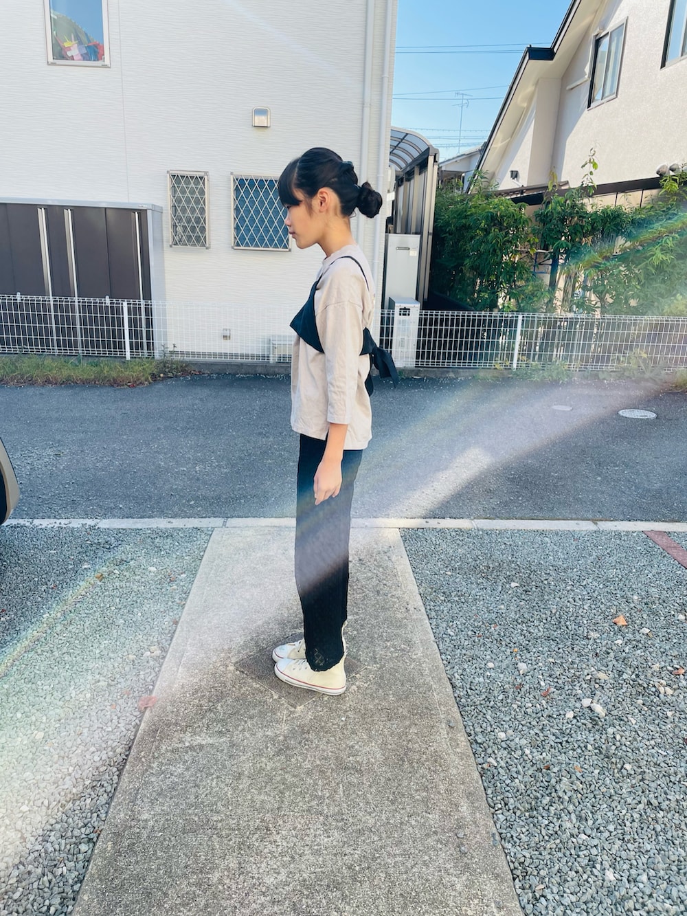 ブラック系のその他パンツ、ホワイト系のスニーカー、ベージュ系のTシャツ/カットソーを着用したキッズの秋コーディネートの2枚目の写真