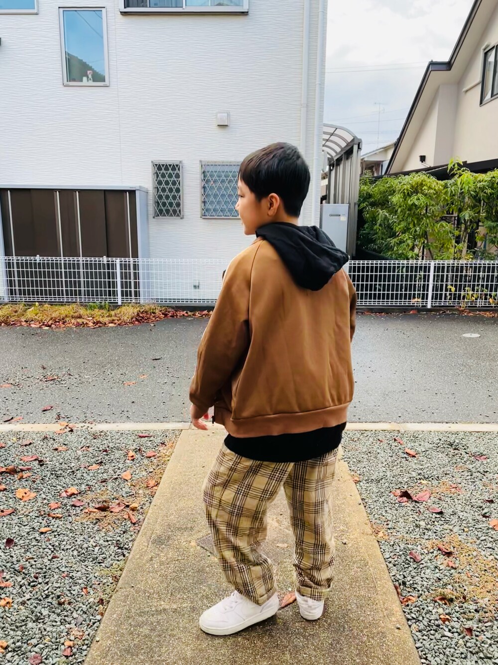 ブラウン系のノーカラージャケット、ベージュ系のその他パンツ、ホワイト系のスニーカーを着用したキッズの冬コーディネートの2枚目の写真