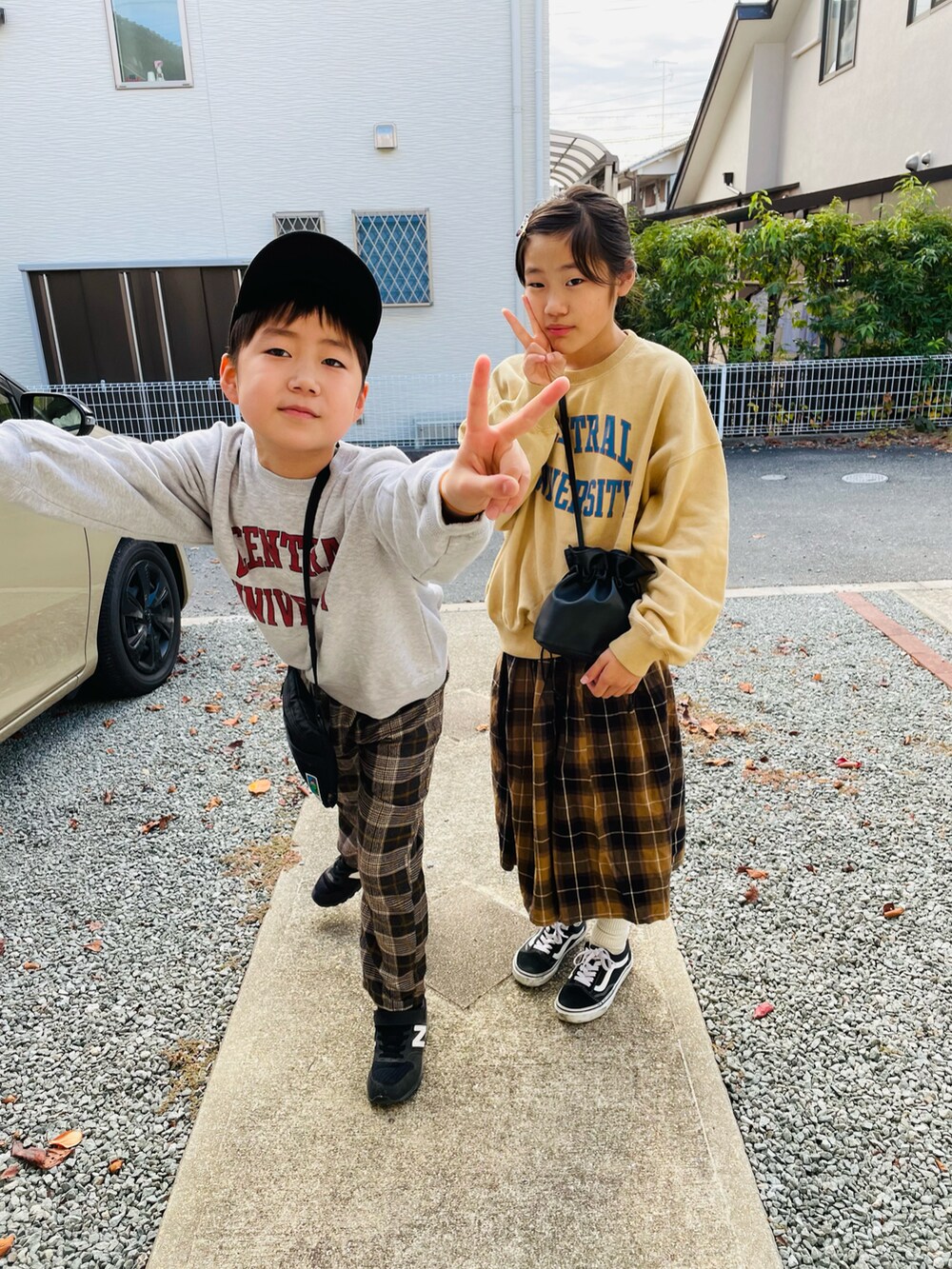 ブラック系のハンドバッグ、ベージュ系のスウェット、グレー系のスウェットを着用したキッズの秋コーディネートの3枚目の写真