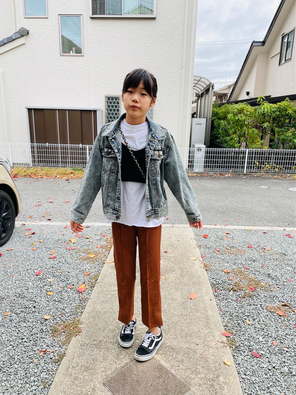 ブルー系のデニムジャケット、ブラウン系のその他パンツ、ブラック系のスニーカーを着用したキッズの秋コーディネートの2枚目の写真
