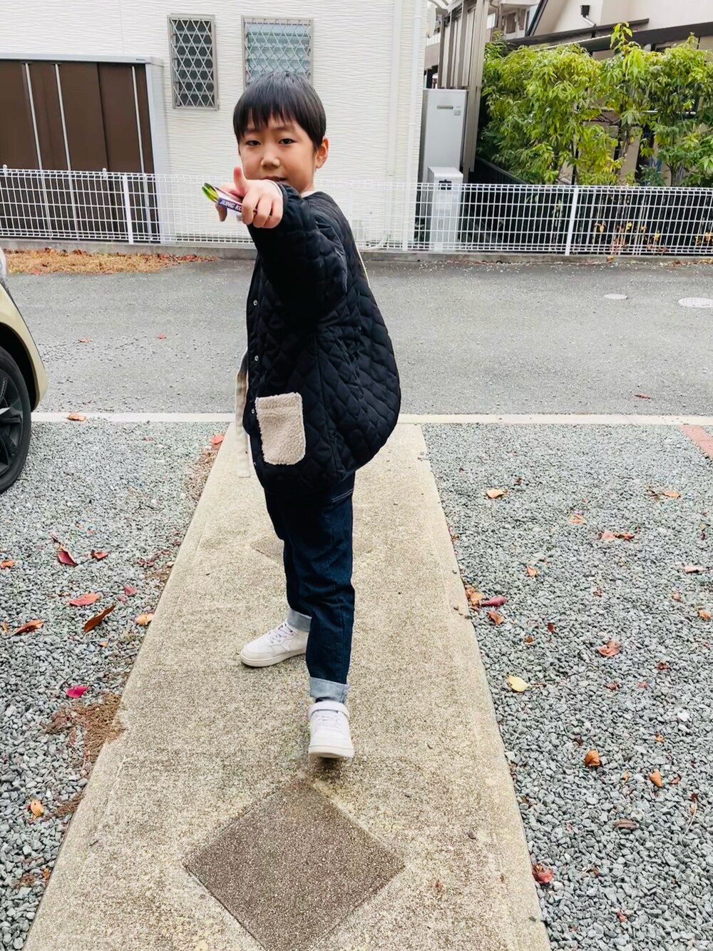 ホワイト系のスニーカー、ブルー系のデニムパンツ、ブラック系のショルダーバッグを着用したキッズの冬コーディネートの2枚目の写真