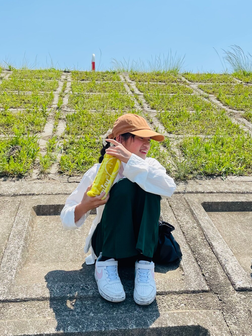 グリーン系のその他パンツ、ホワイト系のTシャツ/カットソー、ブラック系のハンドバッグを着用したキッズの春コーディネートの5枚目の写真