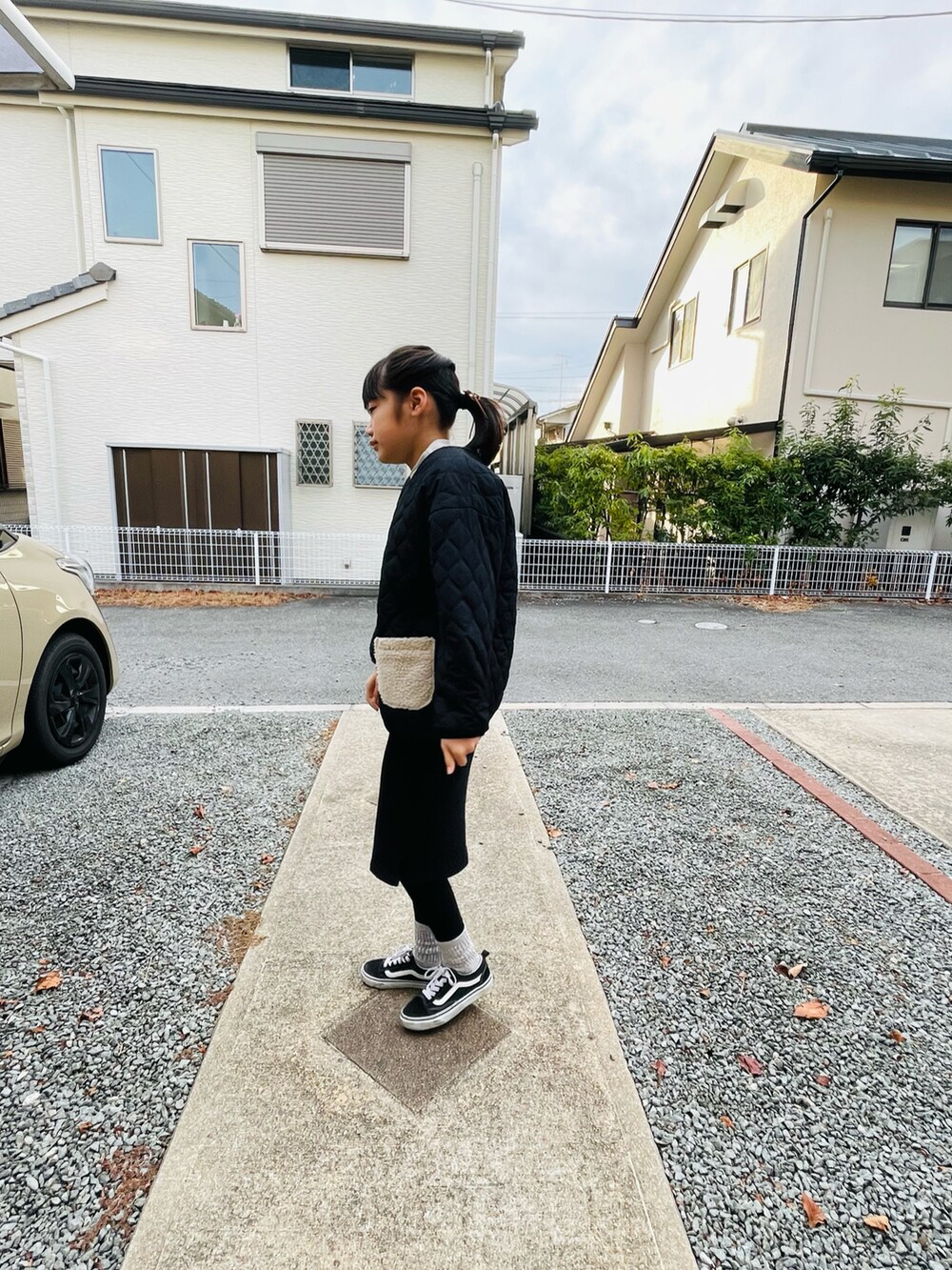 ブラック系のブルゾン、ブラック系のスカート、ブラック系のスニーカーを着用したキッズの冬コーディネートの2枚目の写真