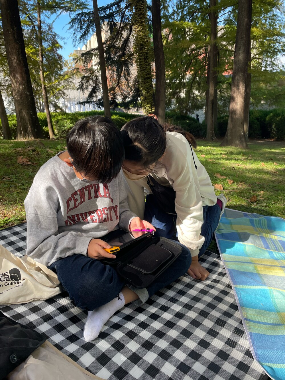 ブルー系のデニムパンツ、ホワイト系のスニーカー、ベージュ系のスウェットを着用したキッズの秋コーディネートの2枚目の写真