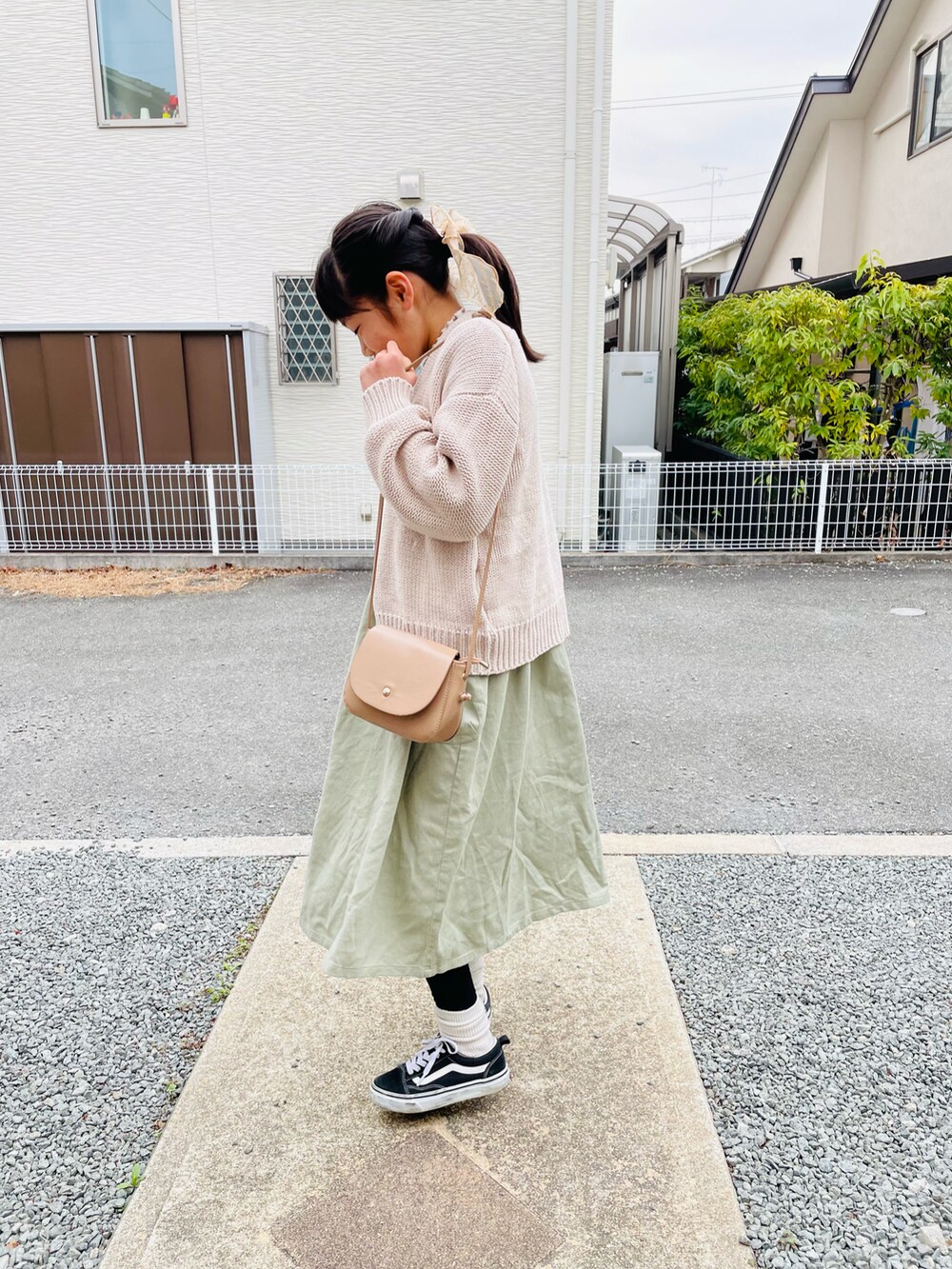 ホワイト系のカーディガン/ボレロ、ベージュ系のショルダーバッグ、グリーン系のワンピースを着用したキッズの春コーディネートの3枚目の写真