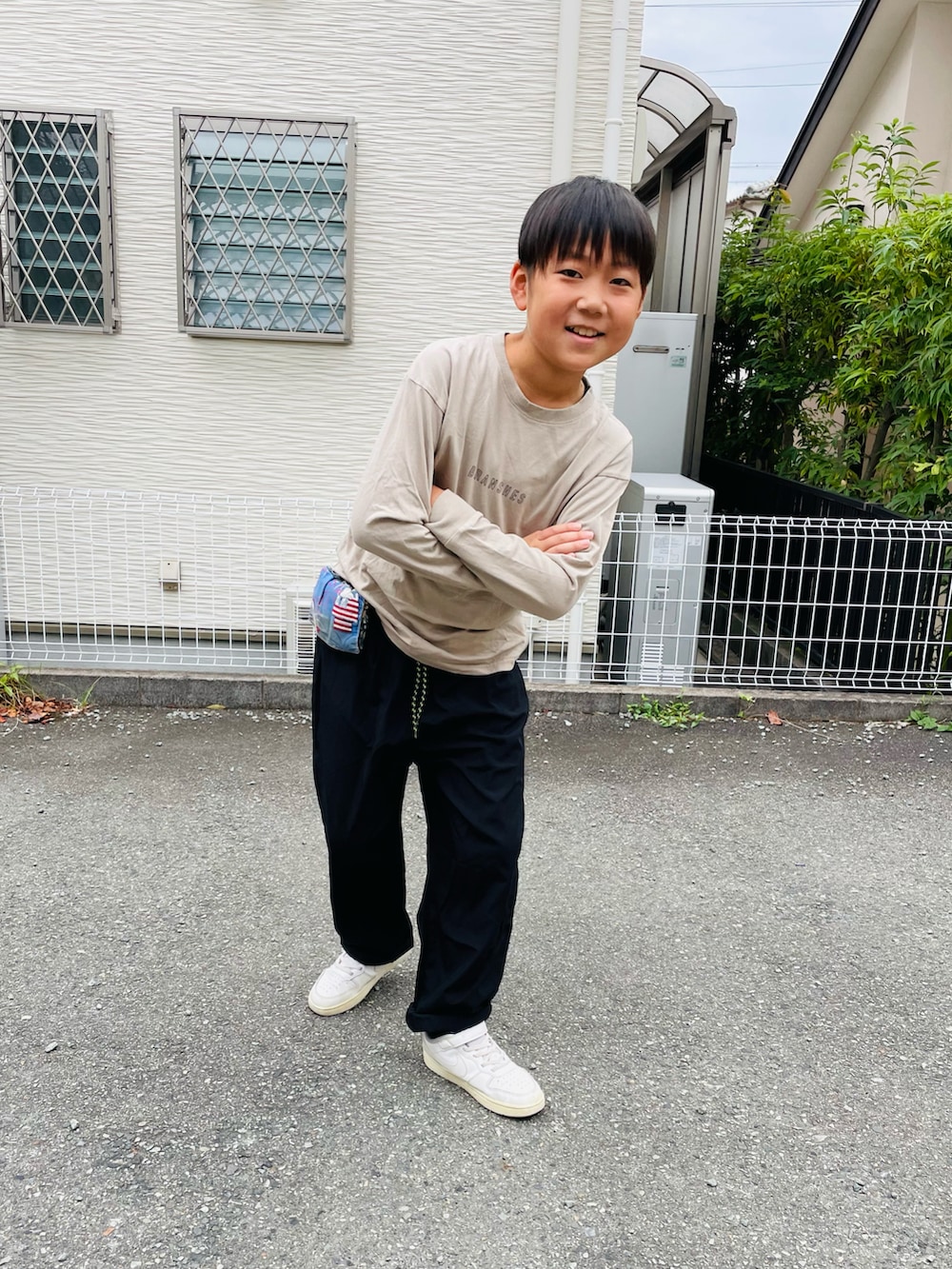 ブラック系のその他パンツ、ホワイト系のスニーカー、ベージュ系のTシャツ/カットソーを着用したキッズの秋コーディネートの2枚目の写真