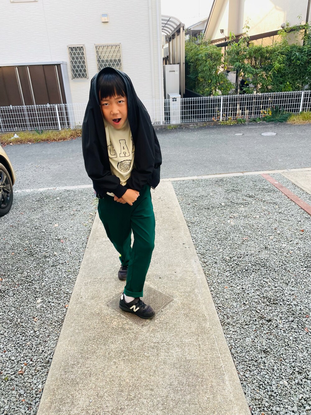 グリーン系のその他パンツ、ブラック系のスニーカー、ホワイト系のスウェットを着用したキッズの秋コーディネートの3枚目の写真