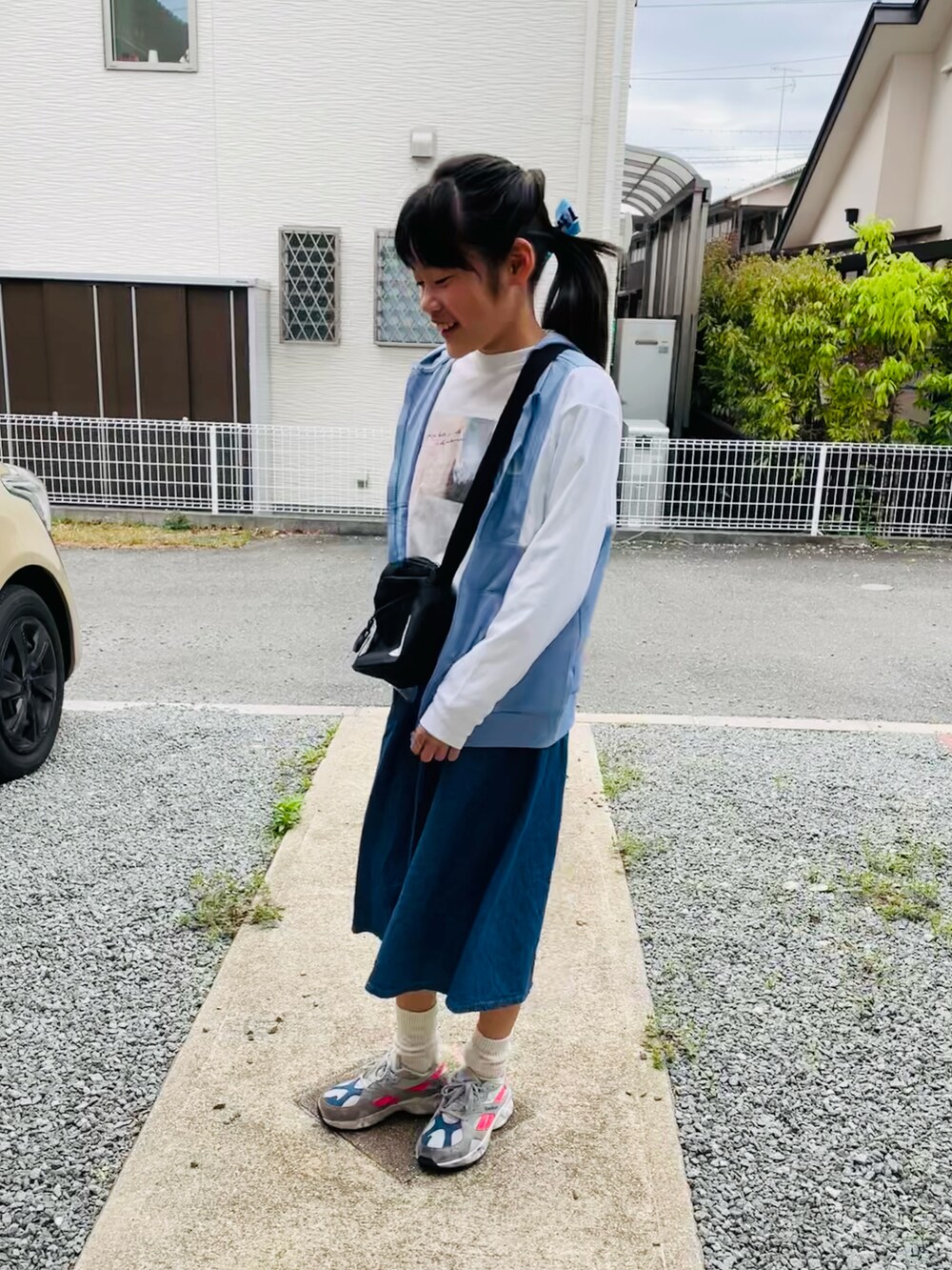 ホワイト系のTシャツ/カットソー、ブルー系のデニムスカート、グレー系のスニーカーを着用したキッズの春コーディネートの2枚目の写真