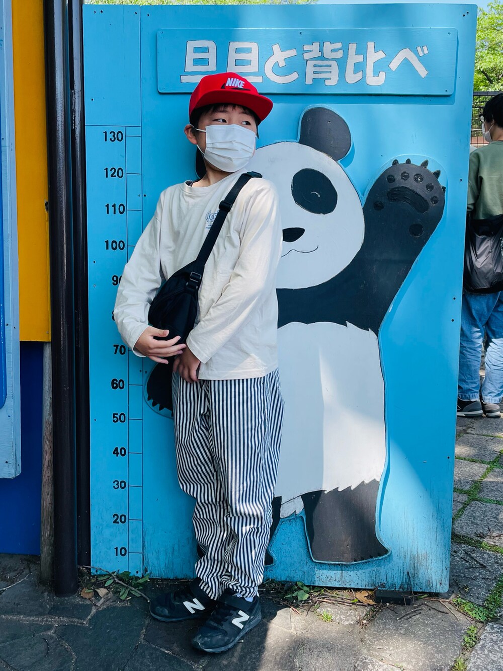 ブラック系のボディバッグ/ウエストポーチ、ホワイト系のその他パンツ、ブラック系のスニーカーを着用したキッズの春コーディネートの3枚目の写真