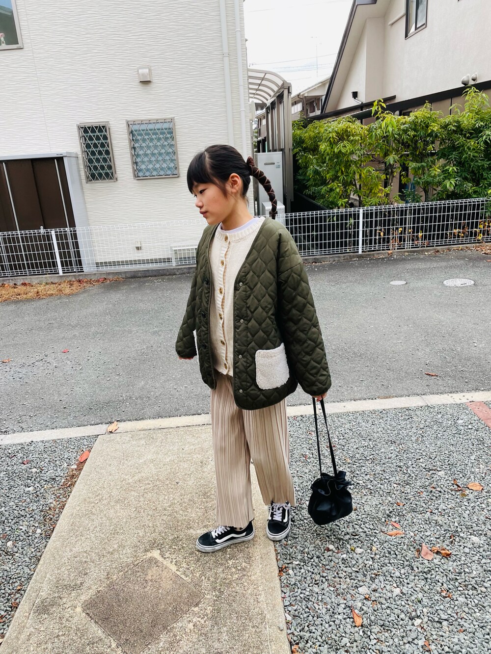 グリーン系のブルゾン、ベージュ系のニット/セーター、ベージュ系のその他パンツを着用したキッズの冬コーディネートの2枚目の写真