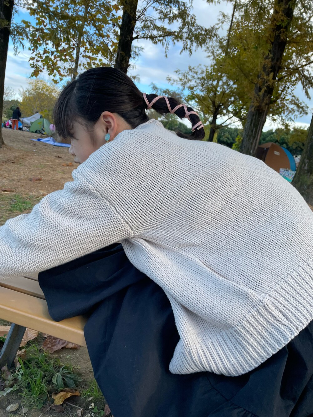 ブラック系のワンピース、ホワイト系のトップス、ベージュ系のスニーカーを着用したキッズの秋コーディネートの5枚目の写真