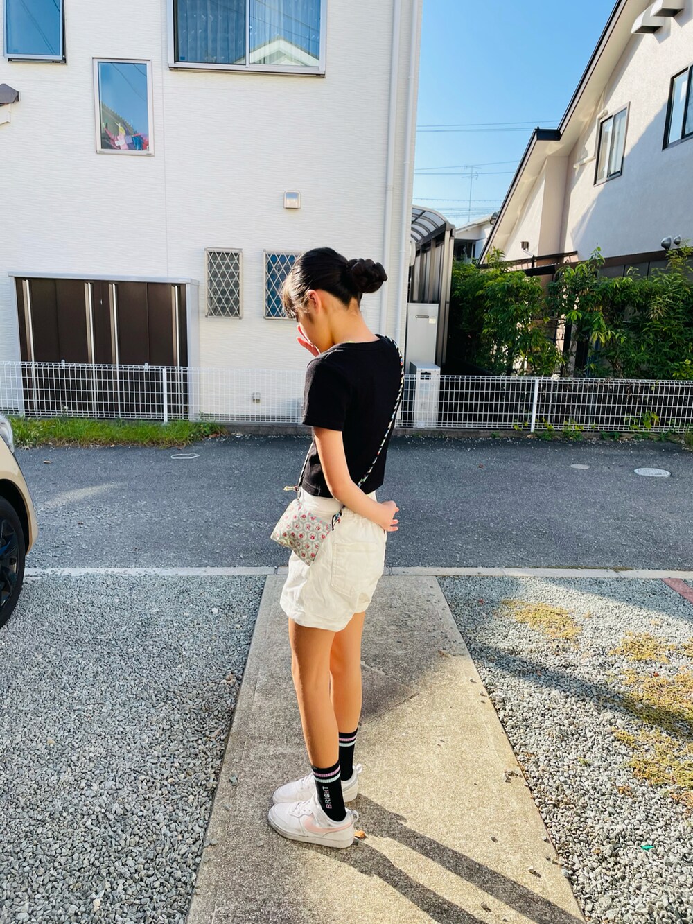 ホワイト系のスニーカー、イエロー系のタンクトップを着用したキッズの秋コーディネートの2枚目の写真