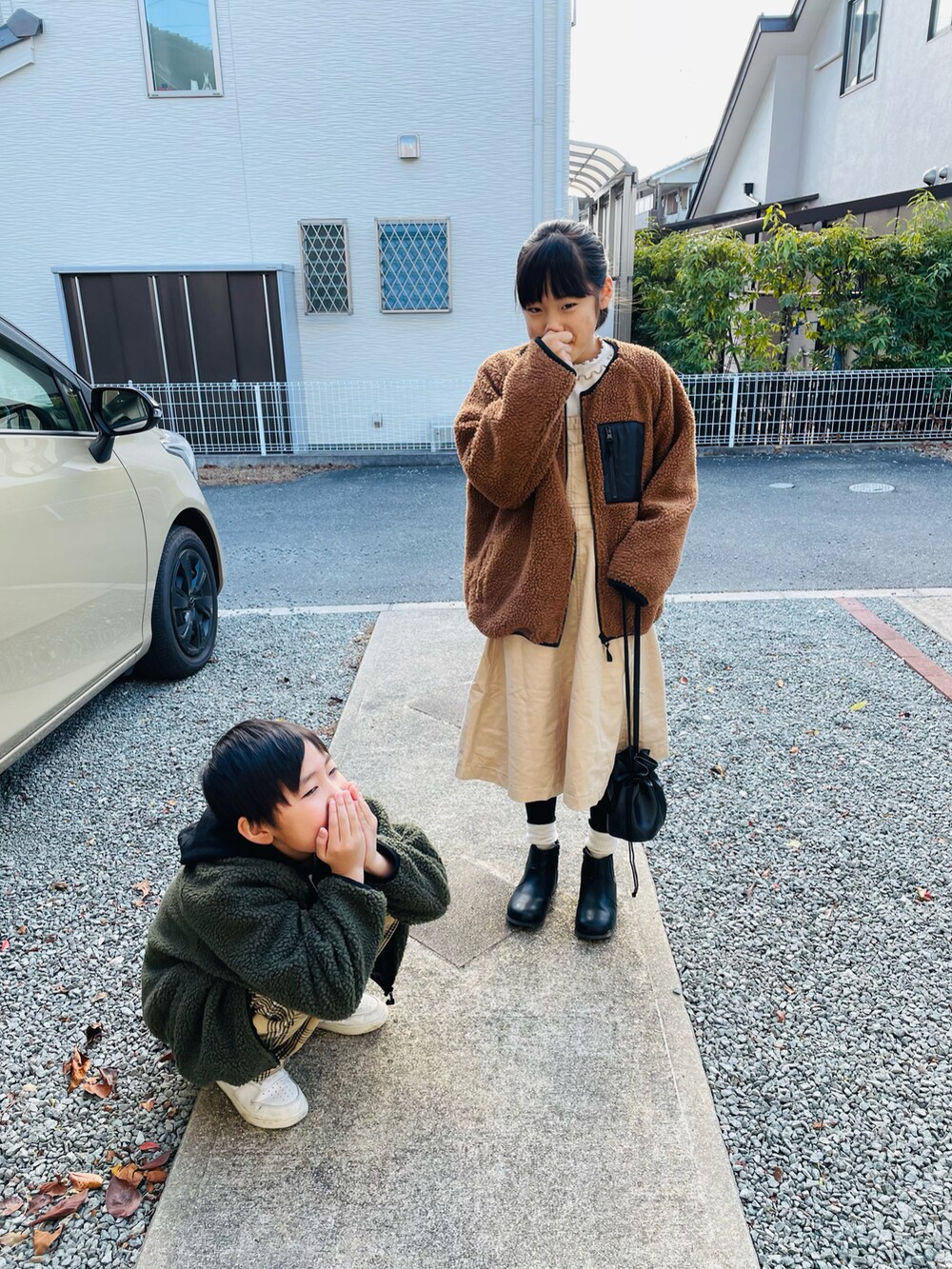 ブラウン系のその他アウター、ベージュ系のジャンパースカート、ブラック系のブーツを着用したキッズの冬コーディネートの2枚目の写真