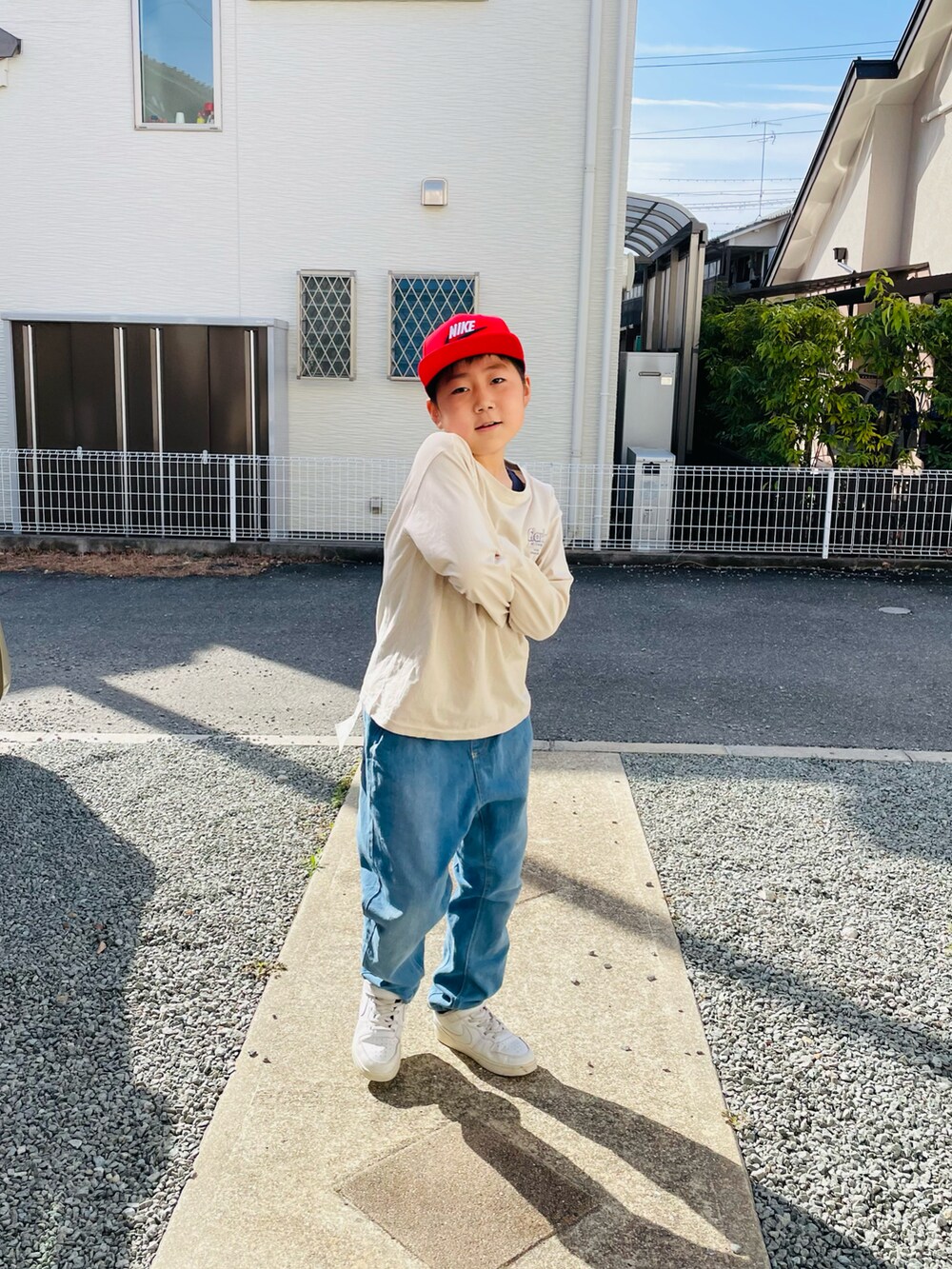 ベージュ系のTシャツ/カットソー、ブルー系のデニムパンツ、ホワイト系のスニーカーを着用したキッズの春コーディネートの2枚目の写真