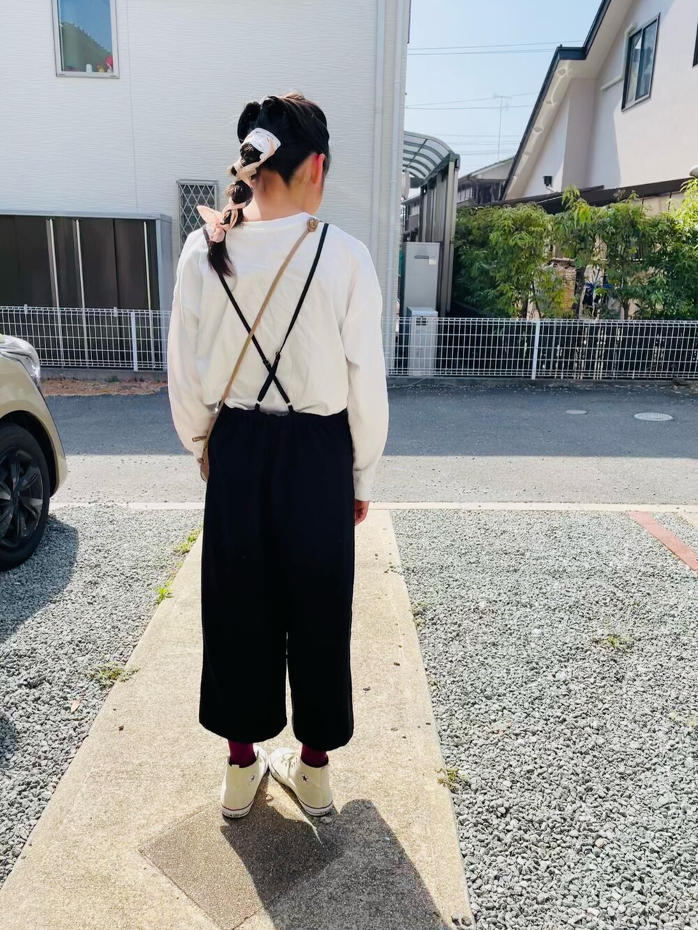 ホワイト系のTシャツ/カットソー、ブラック系のサロペット/オーバーオール、ベージュ系のショルダーバッグを着用したキッズの春コーディネートの2枚目の写真