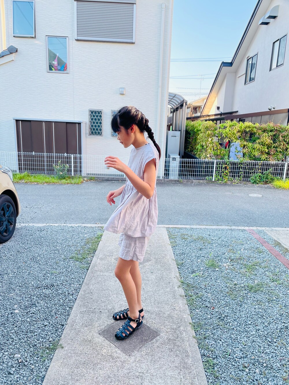 ピンク系のオールインワン・サロペット、ブラック系のサンダル、ブラック系のタンクトップを着用したキッズの夏コーディネートの2枚目の写真