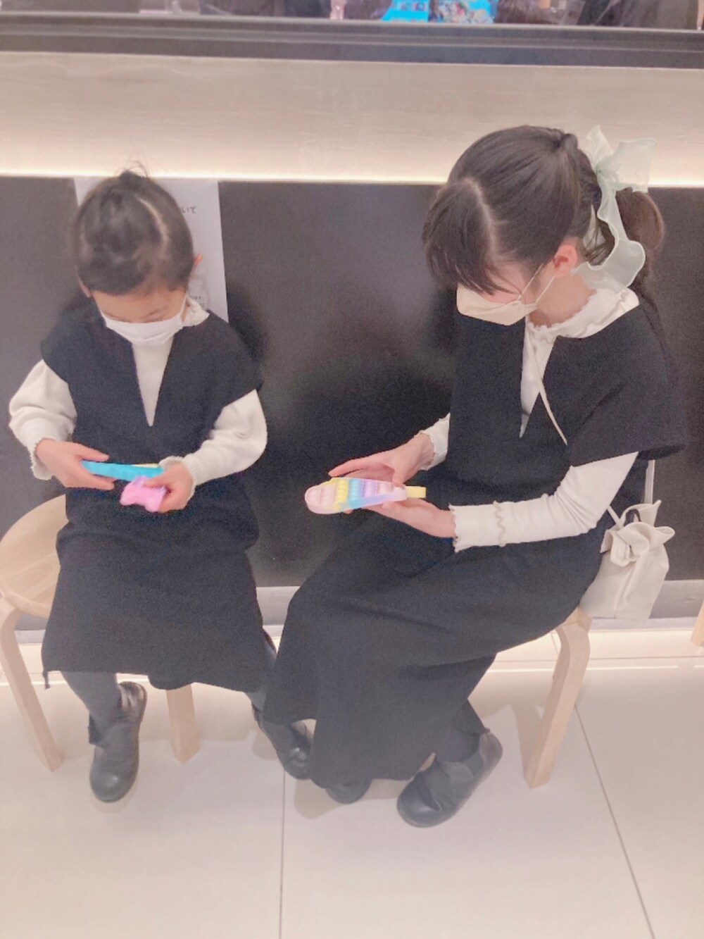 ブラック系のダウンジャケット/コート、ブラック系のジャンパースカート、ブラック系のブーツを着用したキッズの冬コーディネートの2枚目の写真