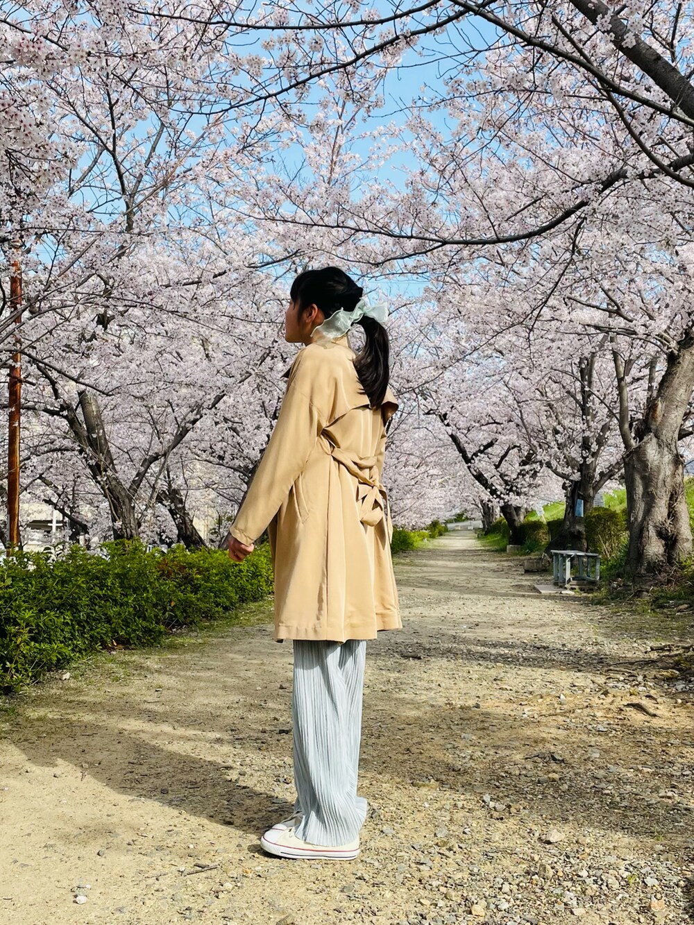 ベージュ系のトレンチコート、ホワイト系のTシャツ/カットソー、グレー系のその他パンツを着用したキッズの春コーディネートの2枚目の写真