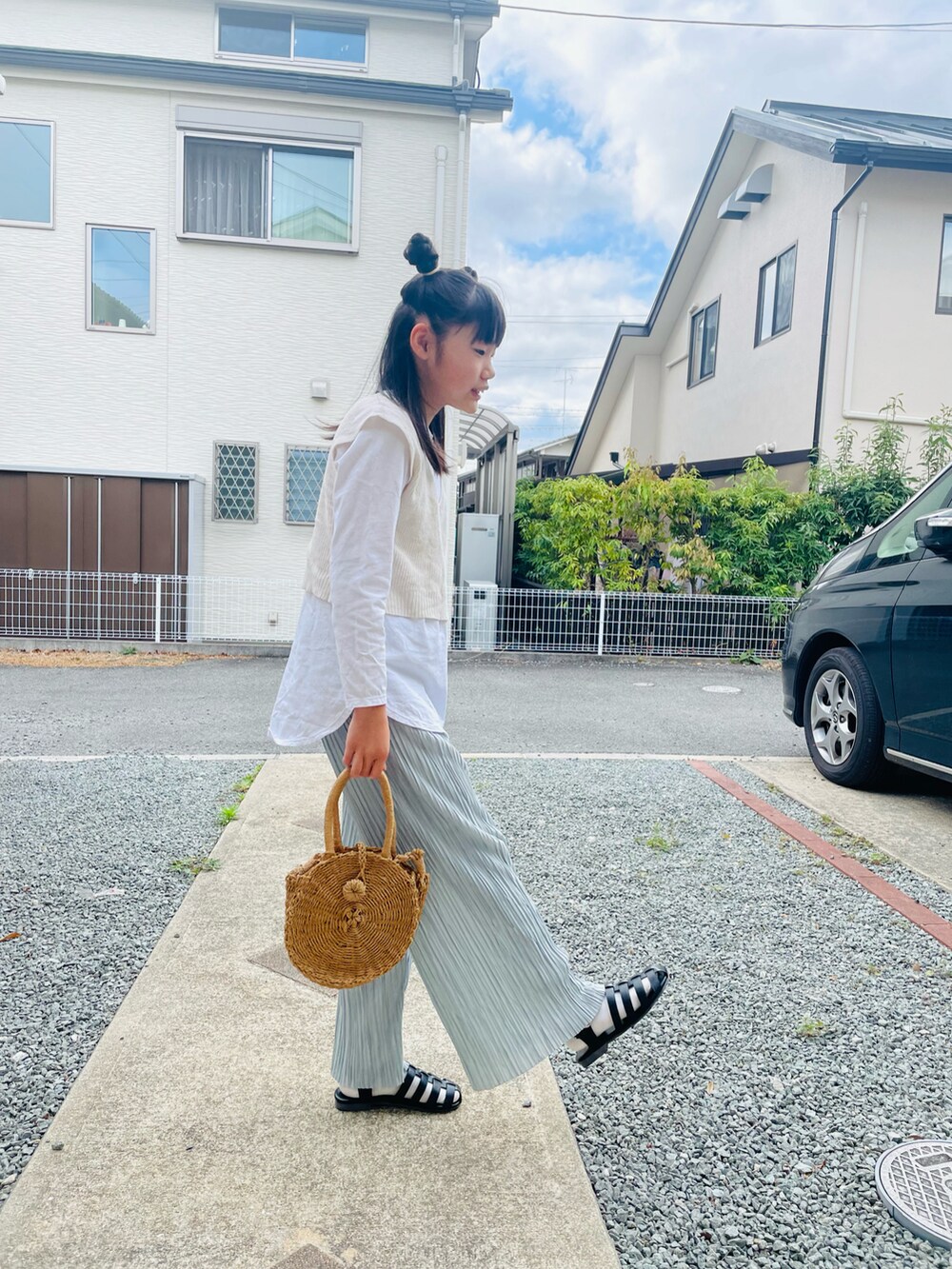 グレー系のその他パンツ、ブラック系のサンダル、ホワイト系のベストを着用したキッズの春コーディネートの2枚目の写真