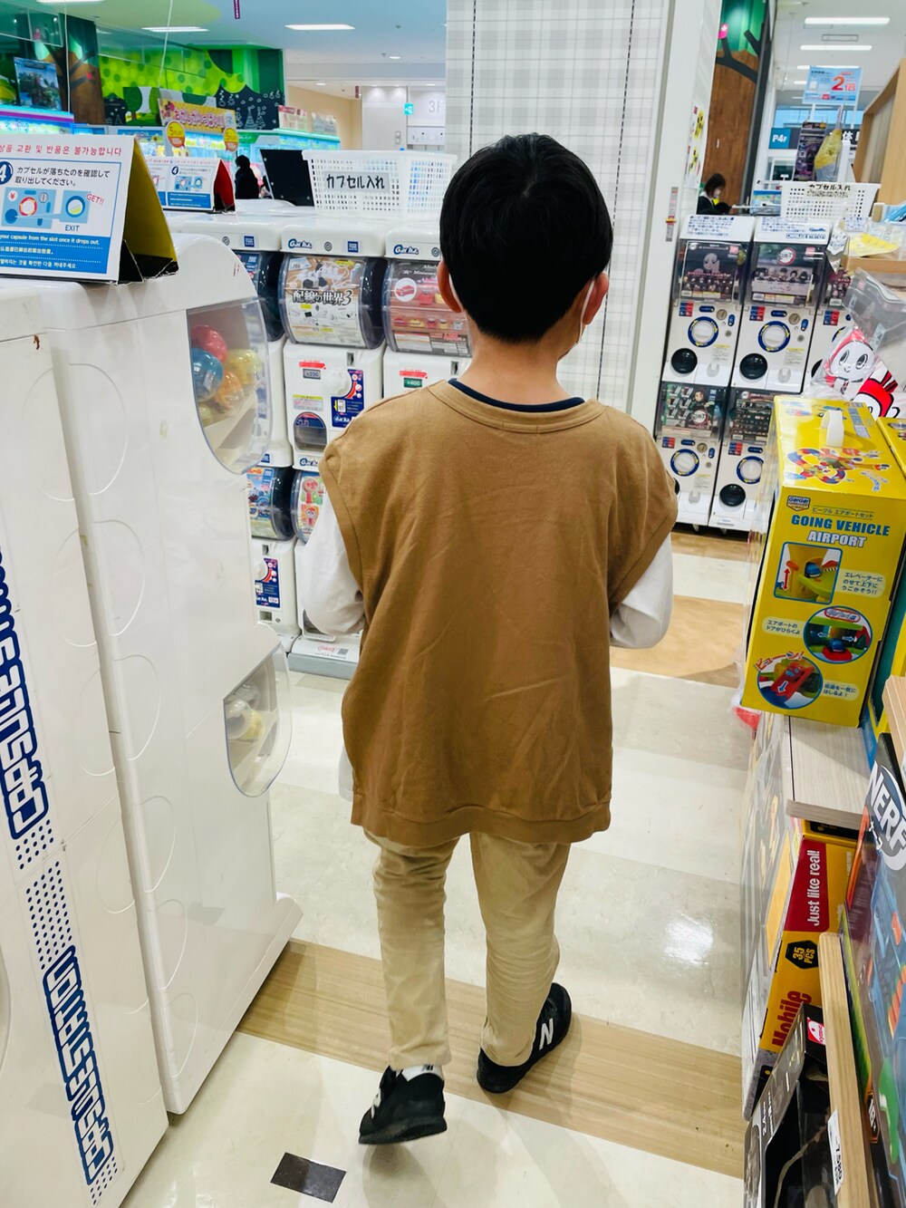 ベージュ系のその他パンツ、ブラウン系のパーカー、ホワイト系のカーディガン/ボレロを着用したキッズの冬コーディネートの3枚目の写真