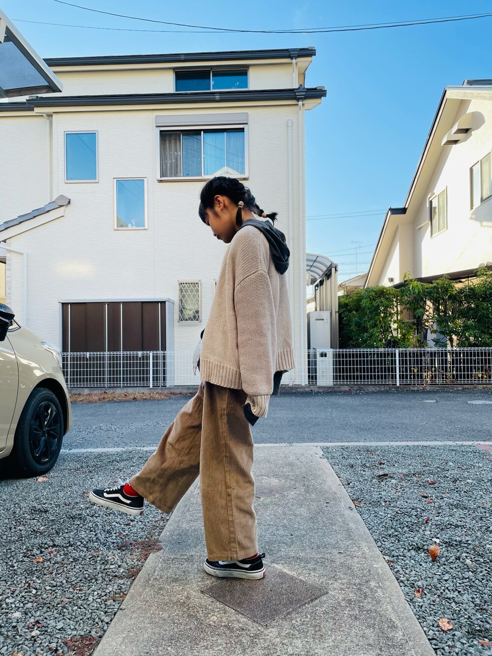 グレー系のパーカー、ホワイト系のカーディガン/ボレロ、ベージュ系のその他パンツを着用したキッズの冬コーディネートの2枚目の写真