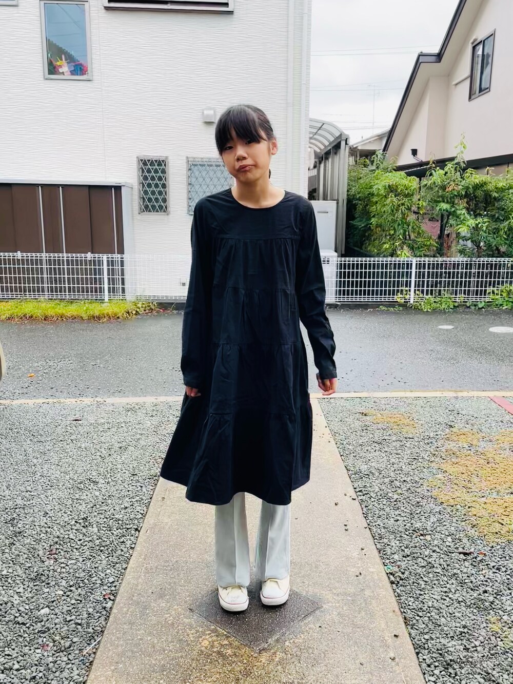 ブラック系のワンピース、グリーン系のその他パンツ、ホワイト系のスニーカーを着用したキッズの秋コーディネートの2枚目の写真