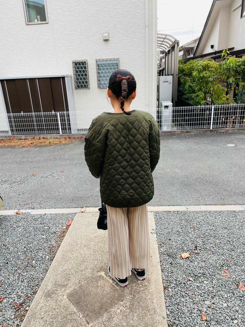 グリーン系のブルゾン、ベージュ系のニット/セーター、ベージュ系のその他パンツを着用したキッズの冬コーディネートの3枚目の写真