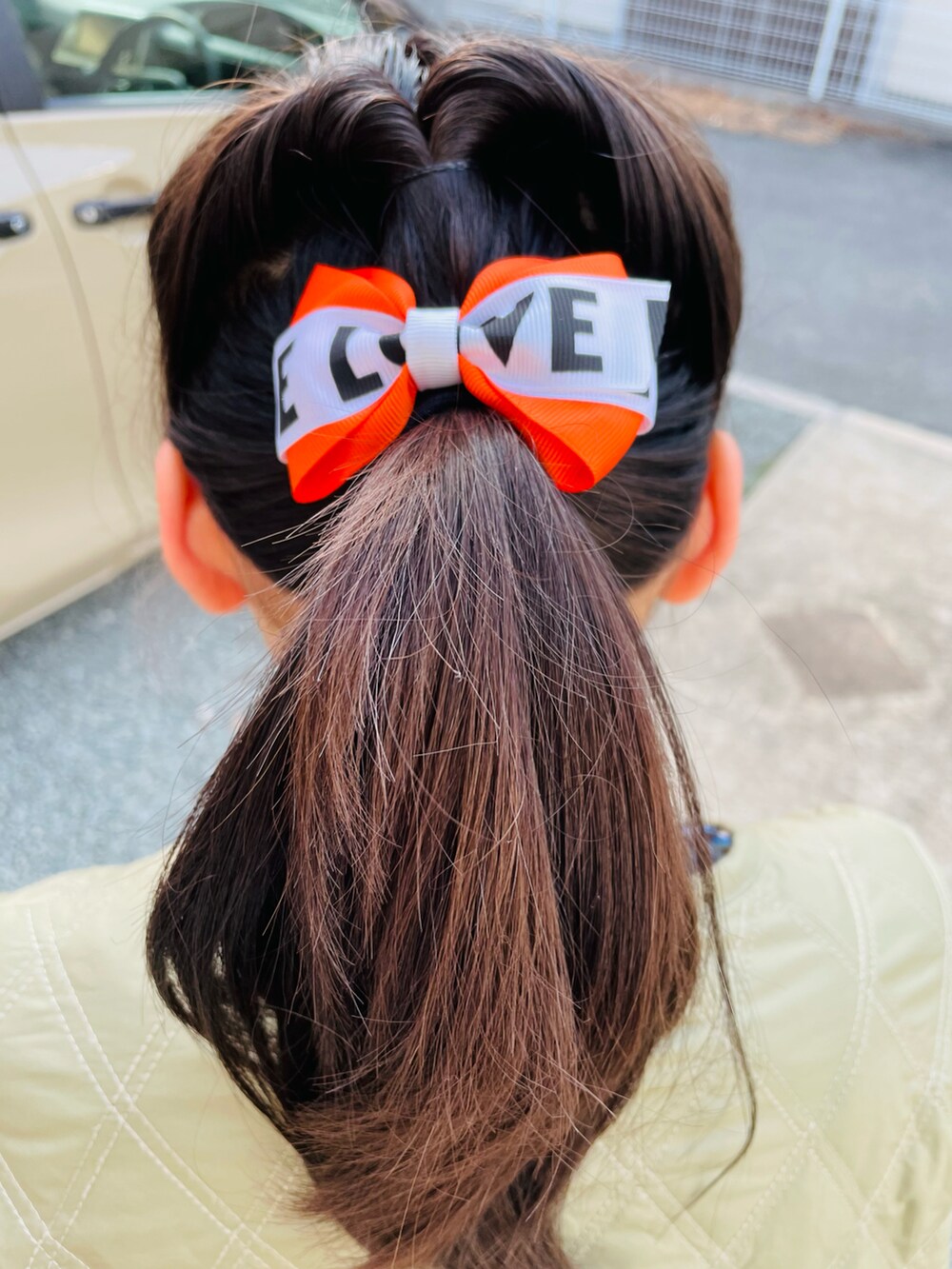 グリーン系のブルゾン、ブラック系のワンピース、ブルー系のデニムパンツを着用したキッズの春コーディネートの4枚目の写真